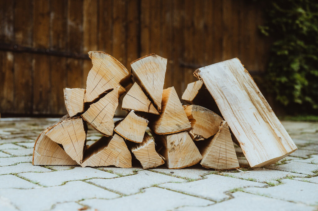 Gestapeltes Holz auf Pflastersteinen.