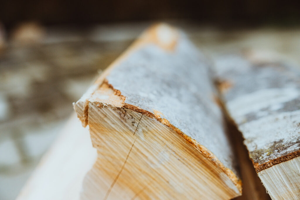 Nahaufnahme gespaltenes Holz, unscharfer Hintergrund.