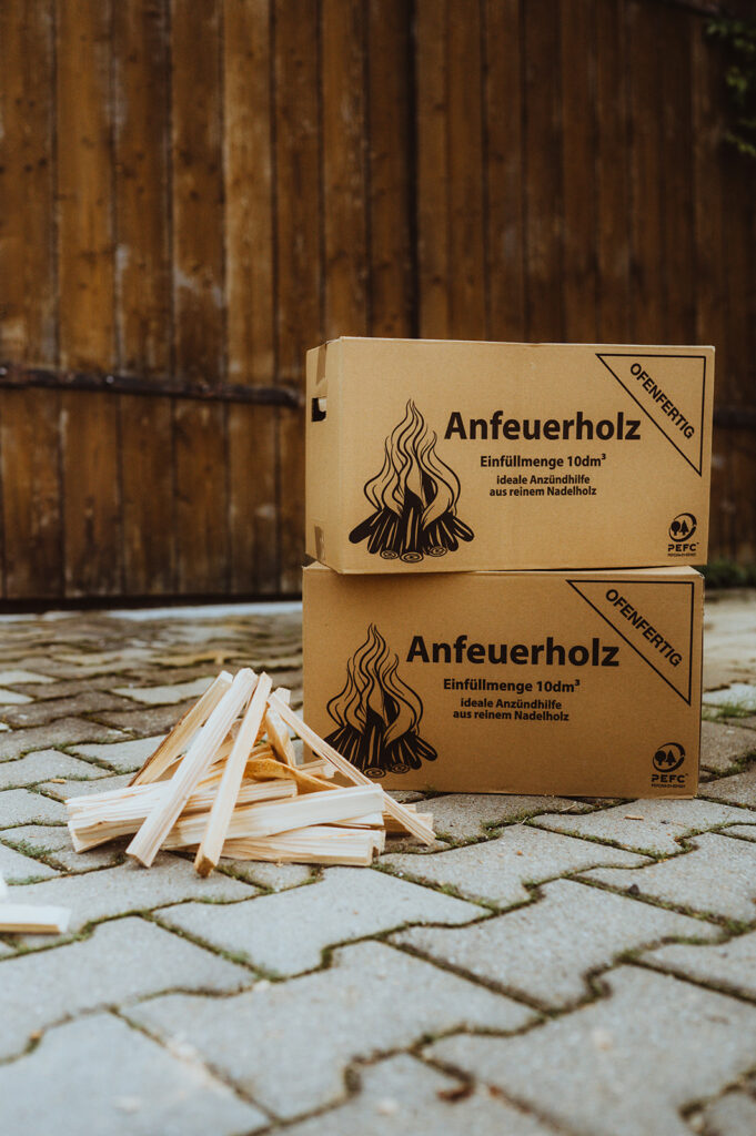 Kartons mit Anfeuerholz auf Pflaster.